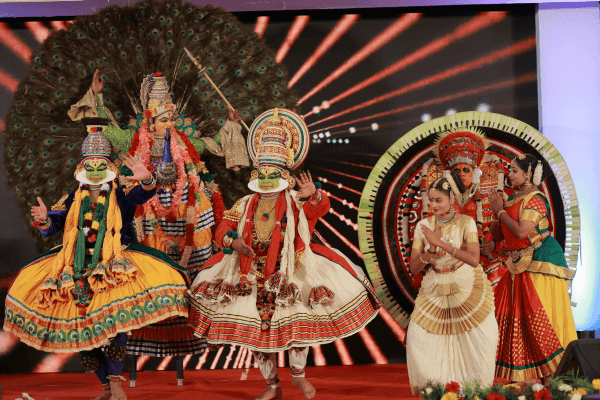 Grupo de dançarinos indianos em trajes tradicionais realizando apresentação cultural no palco.