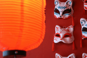 Lanternas vermelhas e máscaras em vitrine oriental.