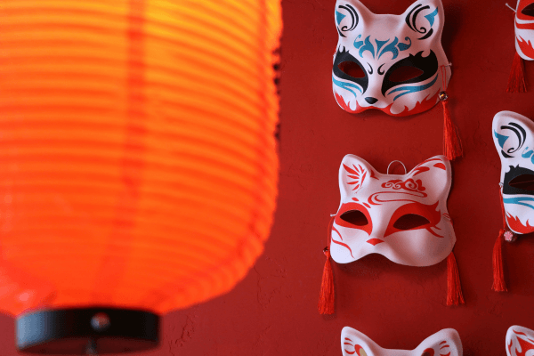 Lanternas vermelhas e máscaras em vitrine oriental.